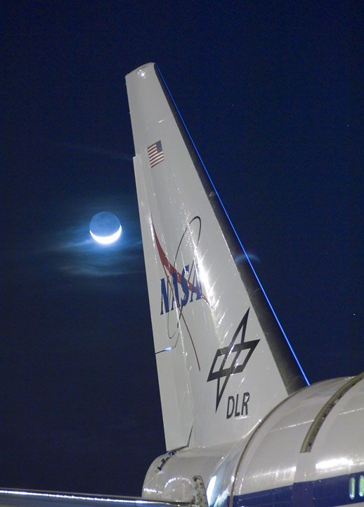 Wispy clouds are illuminated by a bright quarter moon behind the tail of NASA's SOFIA flying observatory during telescope characterization testing in March 2008 - Photo NASA Ames Research Center