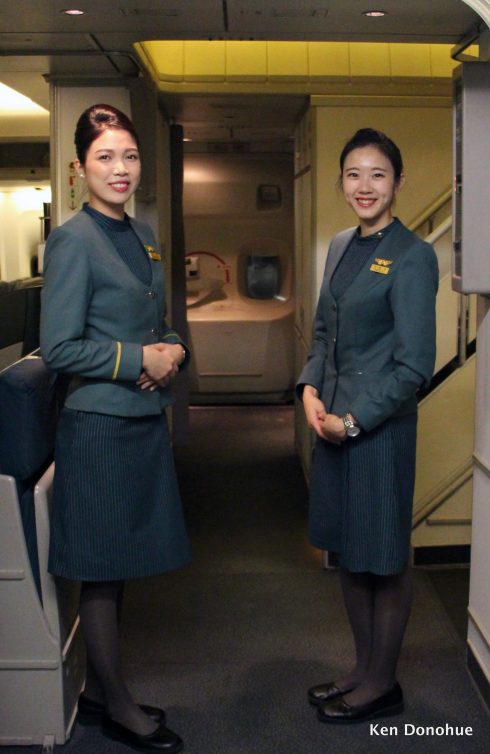 Flight attendants welcome me onboard. 