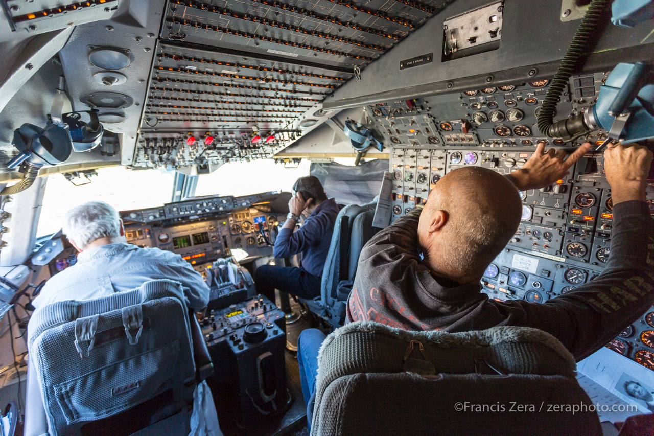 The flight crew prepares the aircraft for takeoff. Lance Pruitt, seated in the foreground, is the flight engineer.