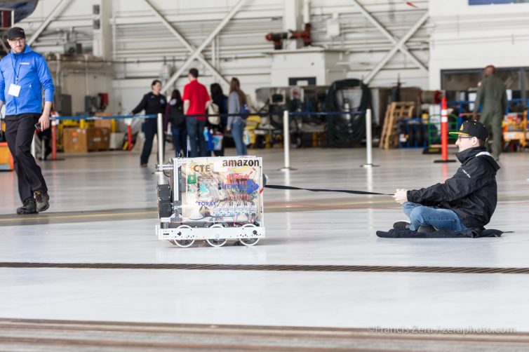 A student demonstrates the pulling power of his robotic team's entry.