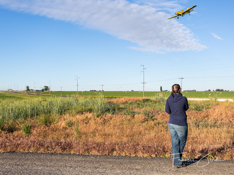 Erin Morse watches as Gavin Morse, her husband and business partner, lines up on a field to start spraying.