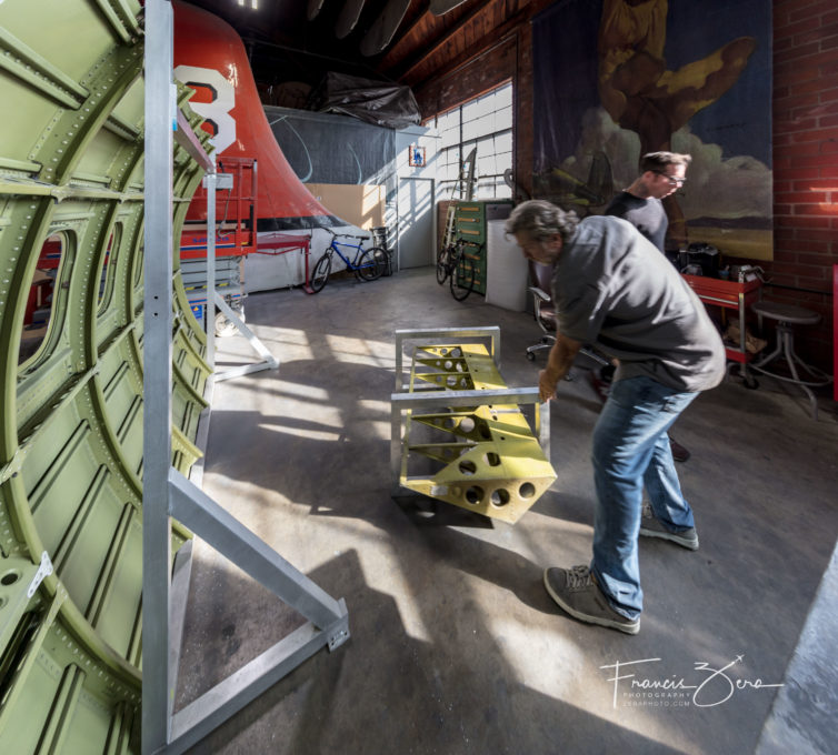 Dave Hall helps one of his crew move a table that's being built in his studio.