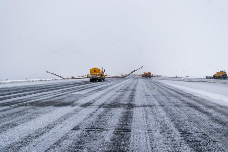 A de-icing truck unfurls its very long boom in preparation for cleaning the center runway at Sea-Tac Airport.