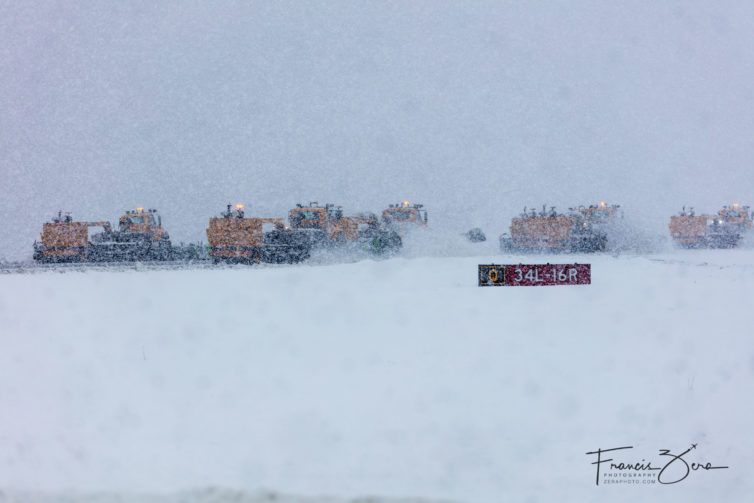 A snow-clearing team heads for the next runway.b