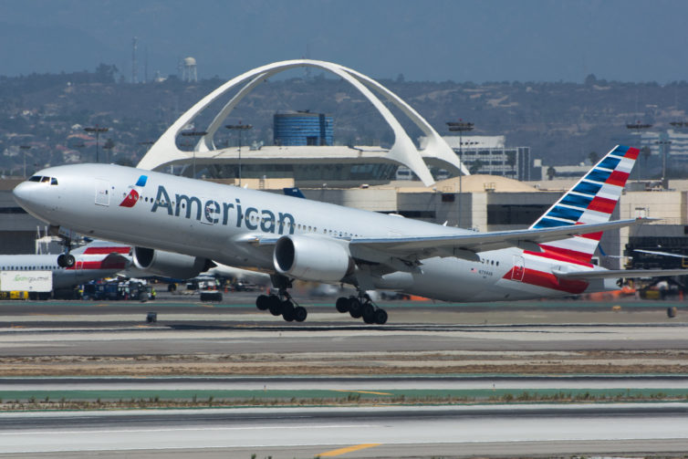 American 777-200ER departing from LAX with the iconic Theme Building and control tower, as seen from the Imperial Hill viewpoint - Photo: Jason Rabinowitz