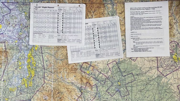 A Seattle sectional chart, the paper flight logs, and the first page of the briefing I wrote up for my checkride