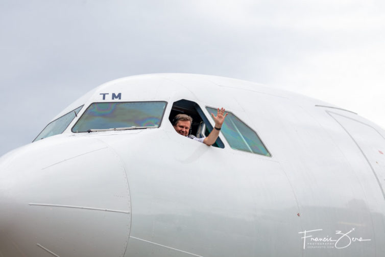 The Finnair captain on the inaugural flight waves to the media that greeted the arrival