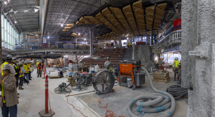A panoramic view of the under-construction main seating area and framing for the tree sculpture at SEA's Concourse C expansion project