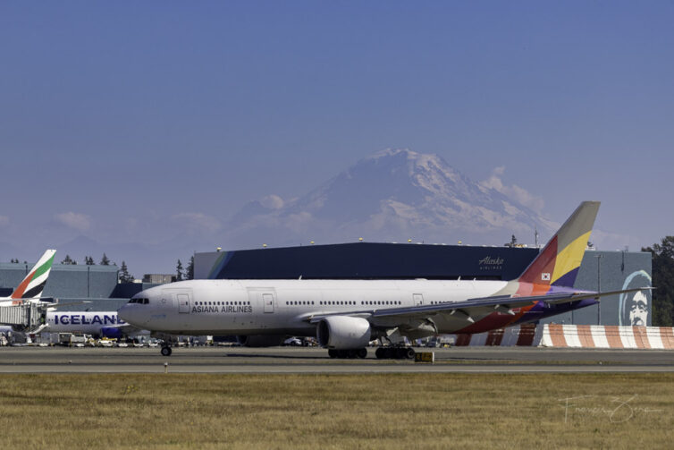 An Asiana 777 parked on a ramp at SEA with Mount Rainier visible in the distance