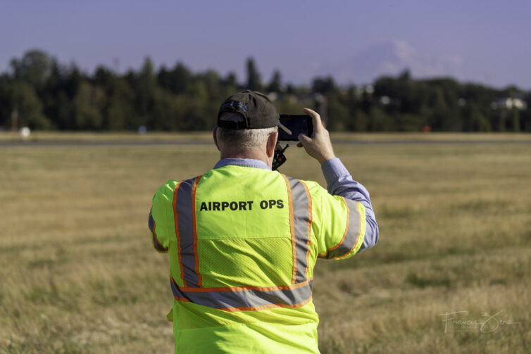 A SEA airport official takes a photo of Mount Rainier