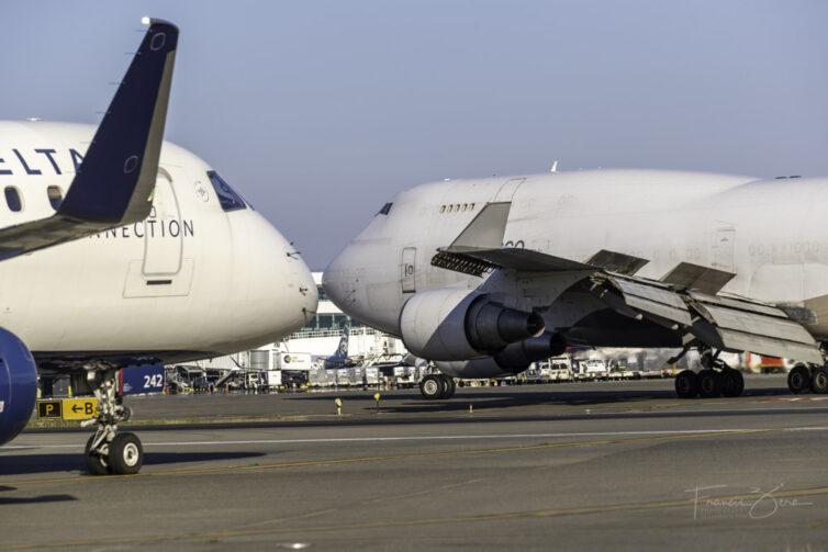 A 747 crosses in front of an A220 at SEA